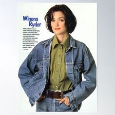 a woman wearing a jean jacket and green shirt is standing with her hands in her pockets