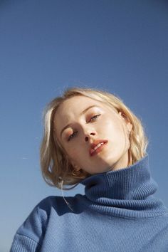 a woman with her eyes closed wearing a blue sweater