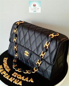 a black cake with gold chains and a chanel bag on top