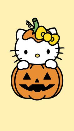 hello kitty sitting on top of a pumpkin