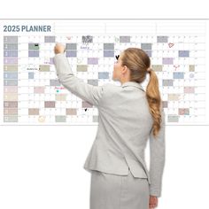 a woman in a business suit pointing to a calendar on a white board with the words planner written across it