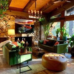 a living room filled with furniture and a fire place next to a stone wall covered in greenery