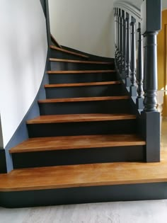 a set of wooden stairs with black railings