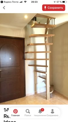 a wooden stair case next to a door in a room with beige walls and tile flooring