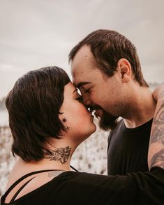 a man and woman kissing each other in the snow