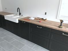 a kitchen with black cabinets and a white sink