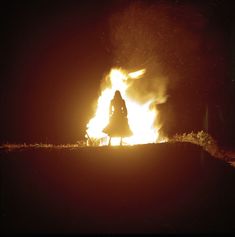 a person standing in front of a fire