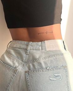 the back of a woman's stomach with her name tattooed on it