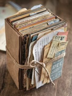 an old book with some tags attached to it on top of a wooden table next to other books