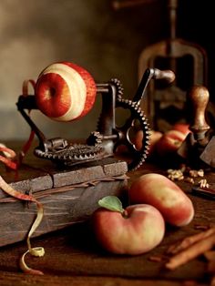 an apple peeler and some apples on a table