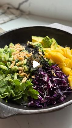 a skillet filled with different types of vegetables and fruit on top of a counter