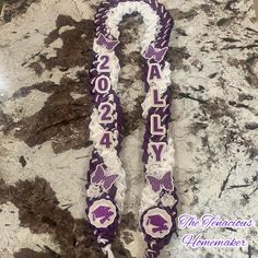 two purple and white graduation lanyards sitting on top of a granite countertop