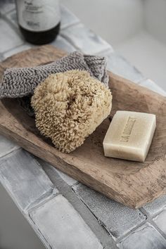 a wooden tray topped with two pieces of soap and a bar of soap on top of it