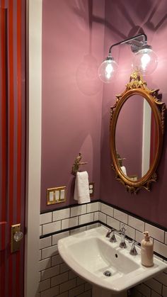 a bathroom sink sitting under a mirror next to a doorway