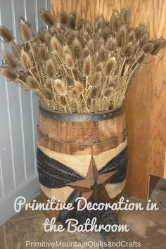 primitive decoration in the bathroom with feathers and star painted on an old wooden barrel as centerpiece