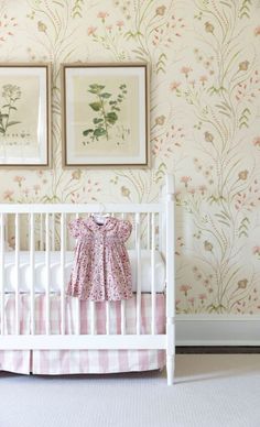 a baby's crib in the corner of a room with floral wallpaper