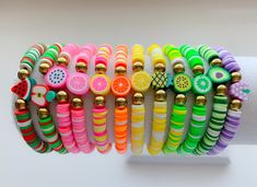 a stack of bracelets with fruit and buttons on them