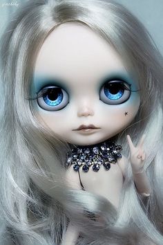 a doll with long white hair and blue eyes