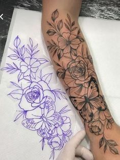 a woman's arm with flowers and leaves on it