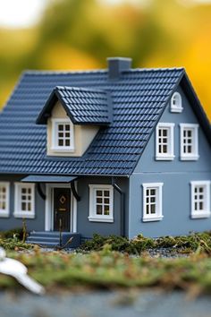 a model house sitting on top of a table next to a pair of white scissors