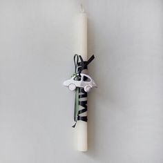 a white candle with a zebra print scarf hanging from it's side on a wall