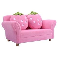 a pink couch with two stuffed strawberrys on it's back and one sitting down