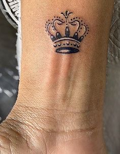 a woman's foot with a crown tattoo on it