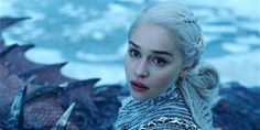 a woman with white hair and blue eyes is standing in front of an ice dragon