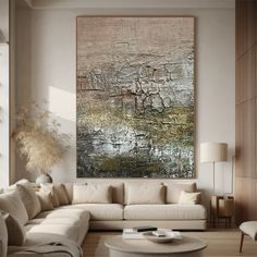 a living room filled with furniture and a large painting hanging on the wall above it