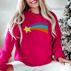 Mabel Rainbow Star Sweatshirt, Mabel Sweater for Cartoon Fans Colorful Star Design Cute and Trendy Sweater Perfect Gift ❣ Features: - Print on Gildan (G5000, G18000, G18500)  - Options: T-shirt, Sweatshirt, Hoodie - Colors: Wide range of colors available - Sizes: Multiple size options to fit everyone ❣ Care Instructions: To keep your Gildan apparel looking fresh and vibrant, follow these care instructions: - Machine Wash: Cold with like colors - Non-Chlorine Bleach: Only when necessary - Tumble Dry: Low - Iron: Medium heat, avoiding the printed area - Do Not Dry Clean ❣ Policies: - Order Changes: No cancellations or changes accepted after 6 hours of placing the order. - Refund Policy: Refunds are available only if requested within 6 hours of placing the order. No returns are accepted. - Re Shooting Star Costume, Mabel Sweater, Hoodie Colors, Star Sweatshirt, Star Costume, Trendy Sweater, Mabel Pines, Cartoon Fan, Cartoon Shirts