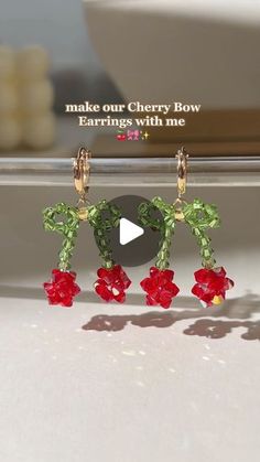 the earrings are made out of green and red flowers with leaves on each earring