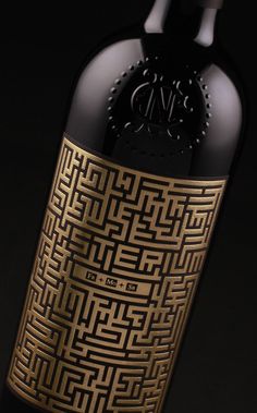 a bottle of wine with an intricate design on the top and bottom, in front of a black background