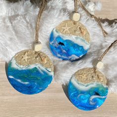 three ornaments with starfish and ocean waves on them