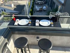 the table is set with plates, silverware and wine bottles on top of the roof