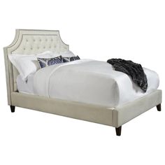 a bed with white linens and pillows on it's headboard, in front of a white background