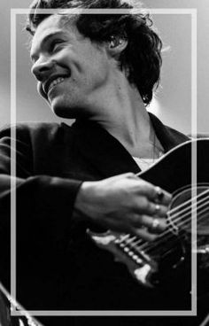 a man playing an acoustic guitar in black and white