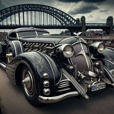 an antique car parked in front of a bridge