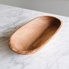 a wooden bowl sitting on top of a marble counter