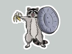 a sticker with a raccoon holding a banana in it's mouth