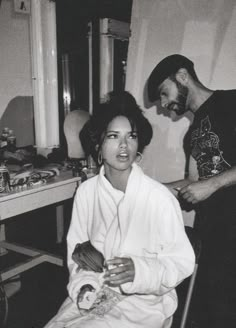 a man standing next to a woman in a room with other items on the table