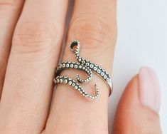 Add a touch of mystical allure to your style with this sterling silver octopus ring. This adjustable tentacle ring wraps around your finger with elegant grace, showcasing the intricate beauty of the sea. Whether you're a fan of punk fashion or a lover of all things oceanic, this ring is the perfect accessory to express your unique personality. Crafted with care and made of high-quality sterling silver, it's a must-have piece for any sea witch or pirate at heart! Rings are sold in sizes 5 6 7 8 9 Octopus Aesthetic, Tentacle Ring, Squid Rings, Tentacles Ring, Pirate Ring, Punk Mode, Witch Ring, Ring Wraps, Wrap Around Ring