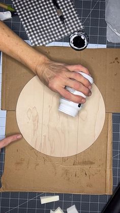 a person is making something out of cardboard on a table with scissors and other crafting supplies