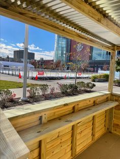 a wooden bench sitting under a metal roof