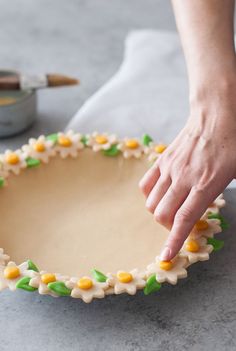 a person is decorating a cake with icing