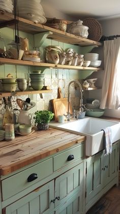 a kitchen filled with lots of open shelves next to a white sink and wooden counter top