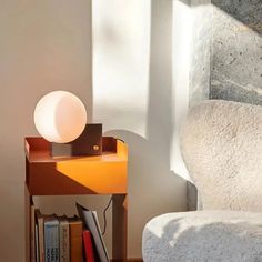 a lamp sitting on top of a table next to a book shelf