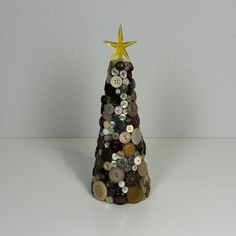 a bottle cap christmas tree with a star on top and buttons all over the base