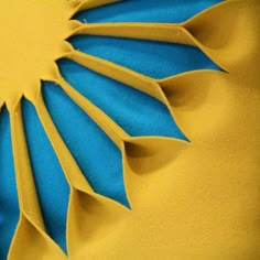 a blue and yellow paper flower on top of a pillow