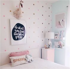 a bedroom with polka dot wallpaper and white bedding, pink pillows and decor