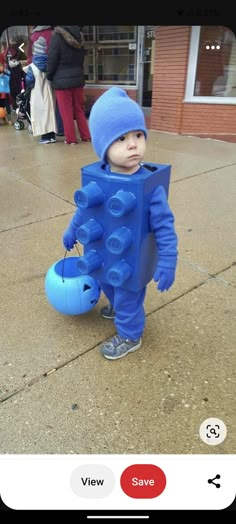 a little boy in a blue suit with lots of buttons on his chest and legs